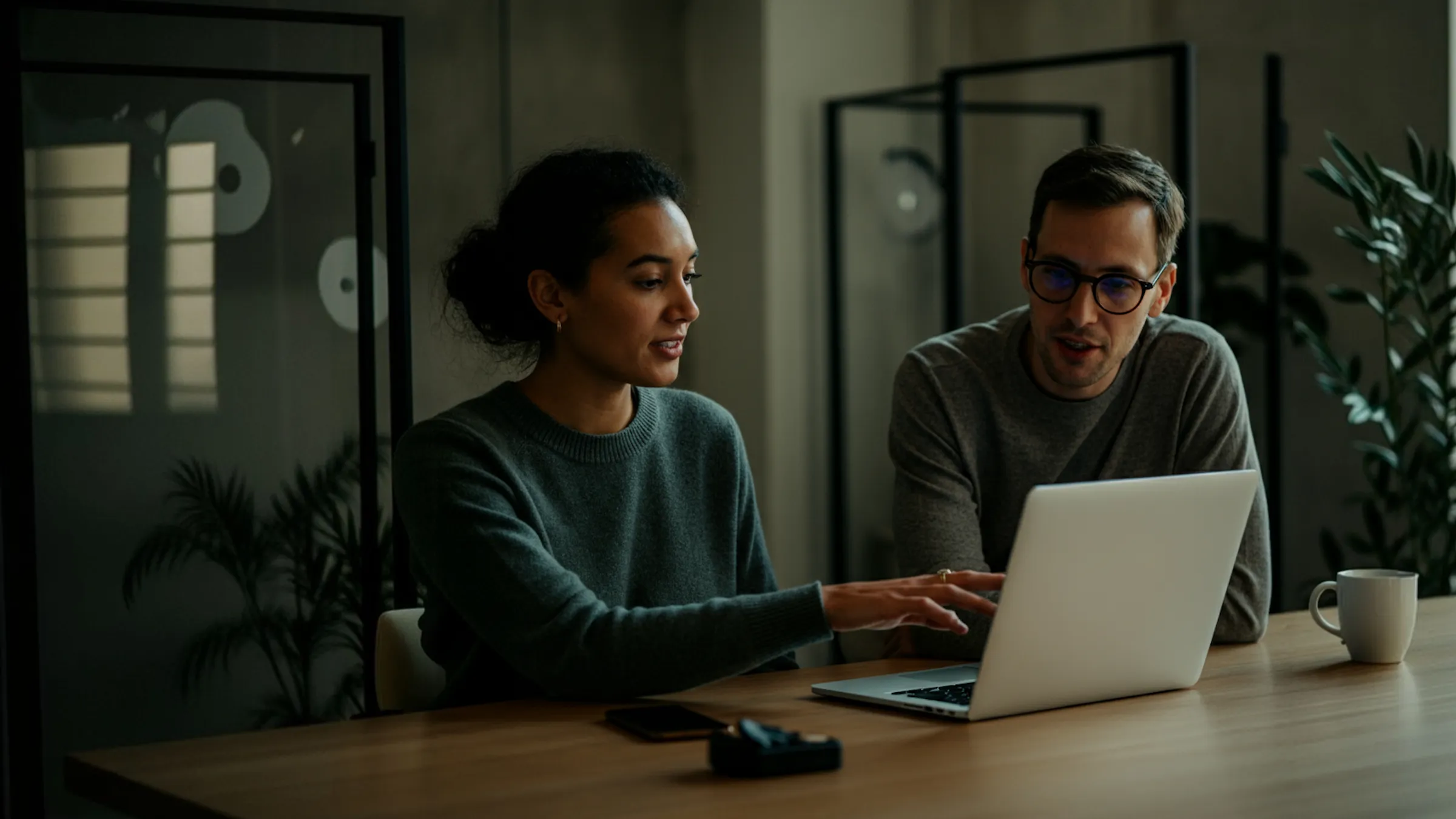 Two colleagues reviewing invoices on a laptop